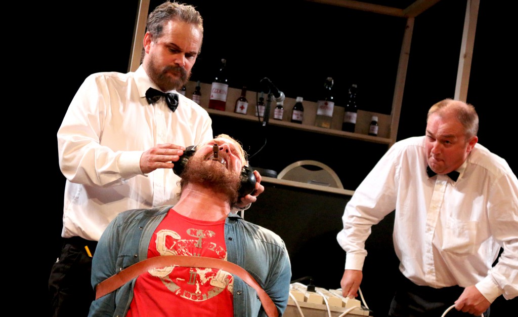 Her får McMurphy, spilt av Cato Hagane, kjenne eletrosjokkbehandling utført av Warren (Øyvind Henriksen) og Williams (Olav Johansen). Foto: Esben Holm Eskelund